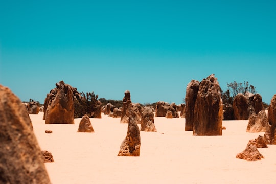 brown rock formation on desert during daytime in Nambung WA Australia