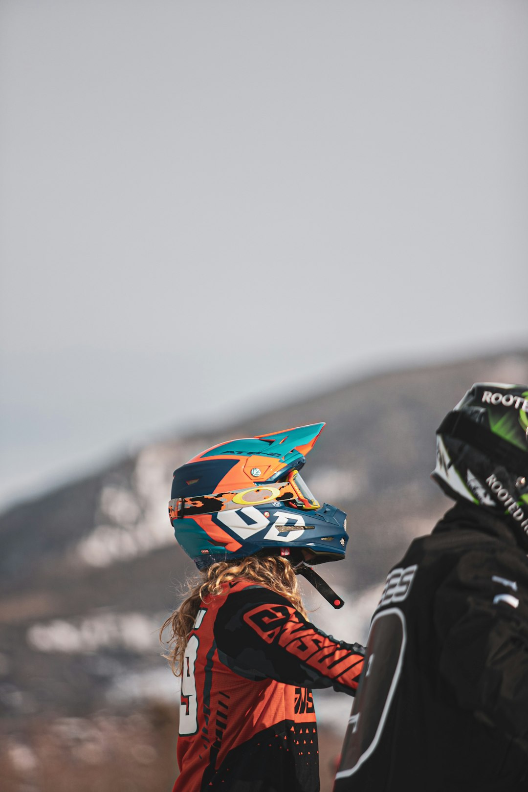 person in orange and black jacket wearing blue and white helmet