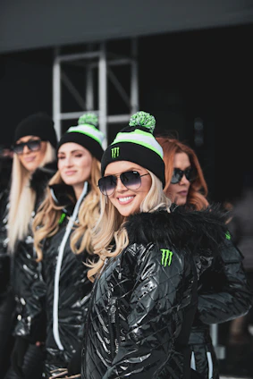 A warm group photo of women leaders and youth smiling together at a community event.
