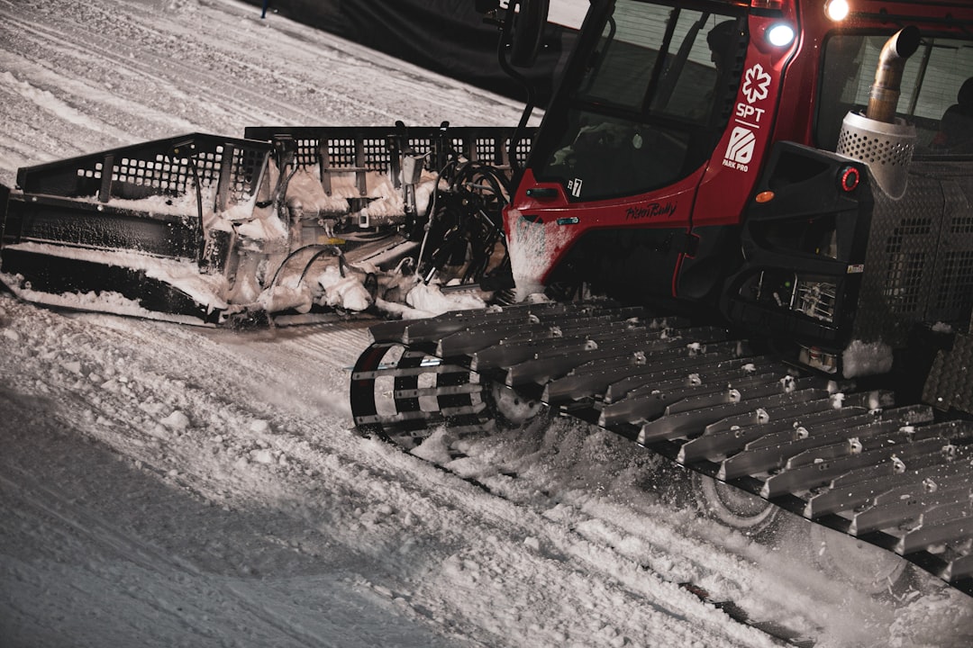red and black heavy equipment on snow covered ground