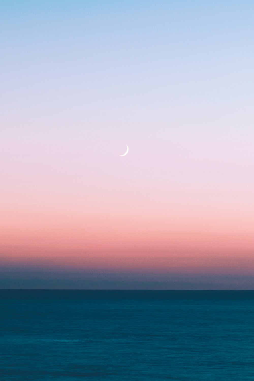 mar azul bajo el cielo blanco durante el día