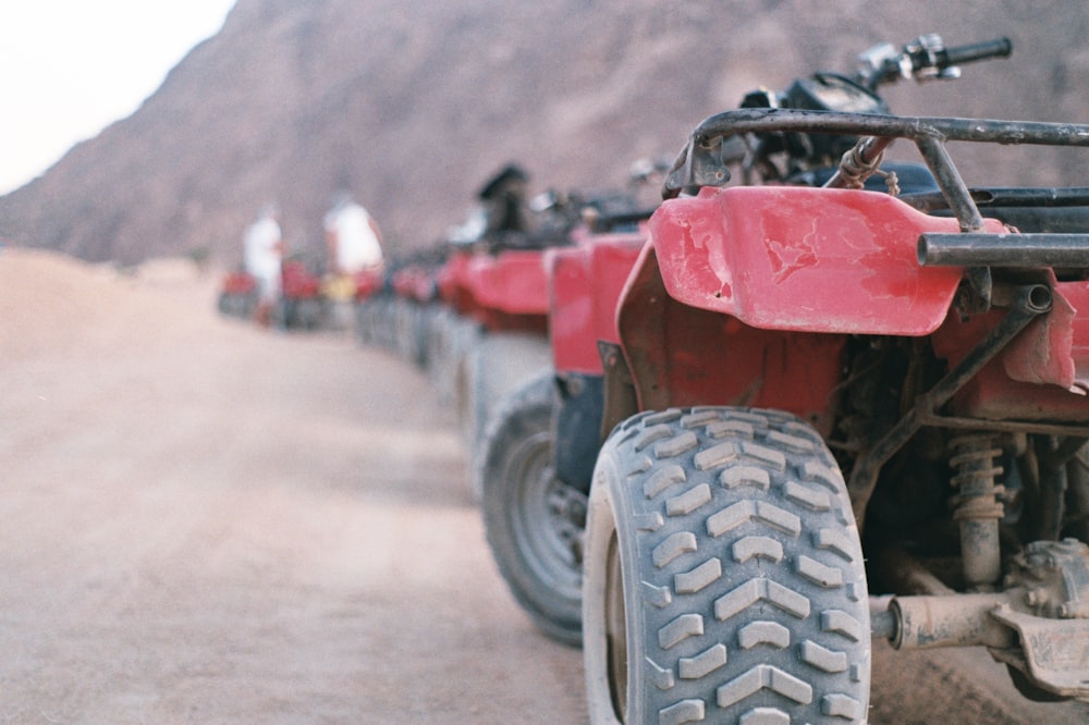 red and black atv on gray sand during daytime