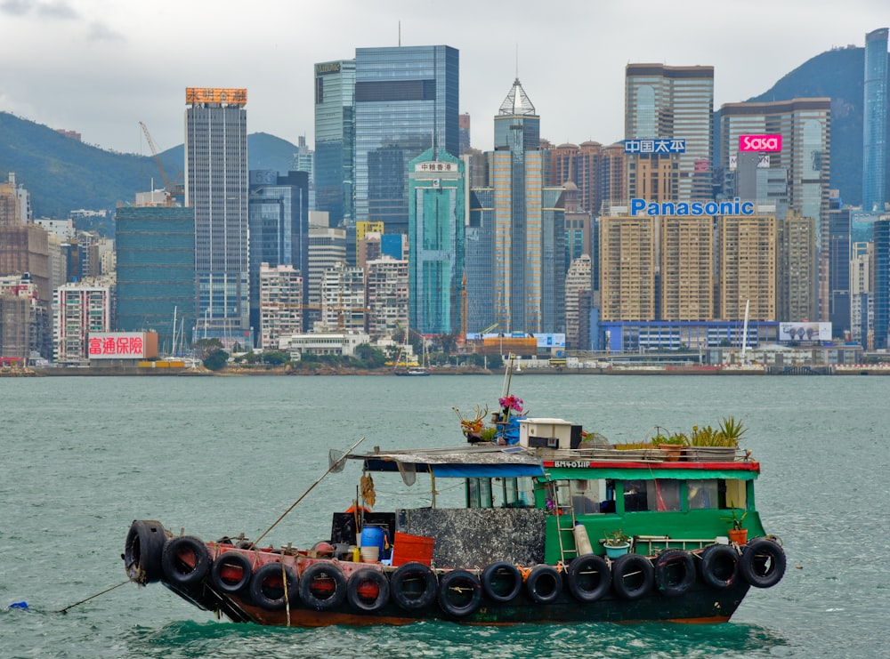 people riding on green boat on body of water during daytime