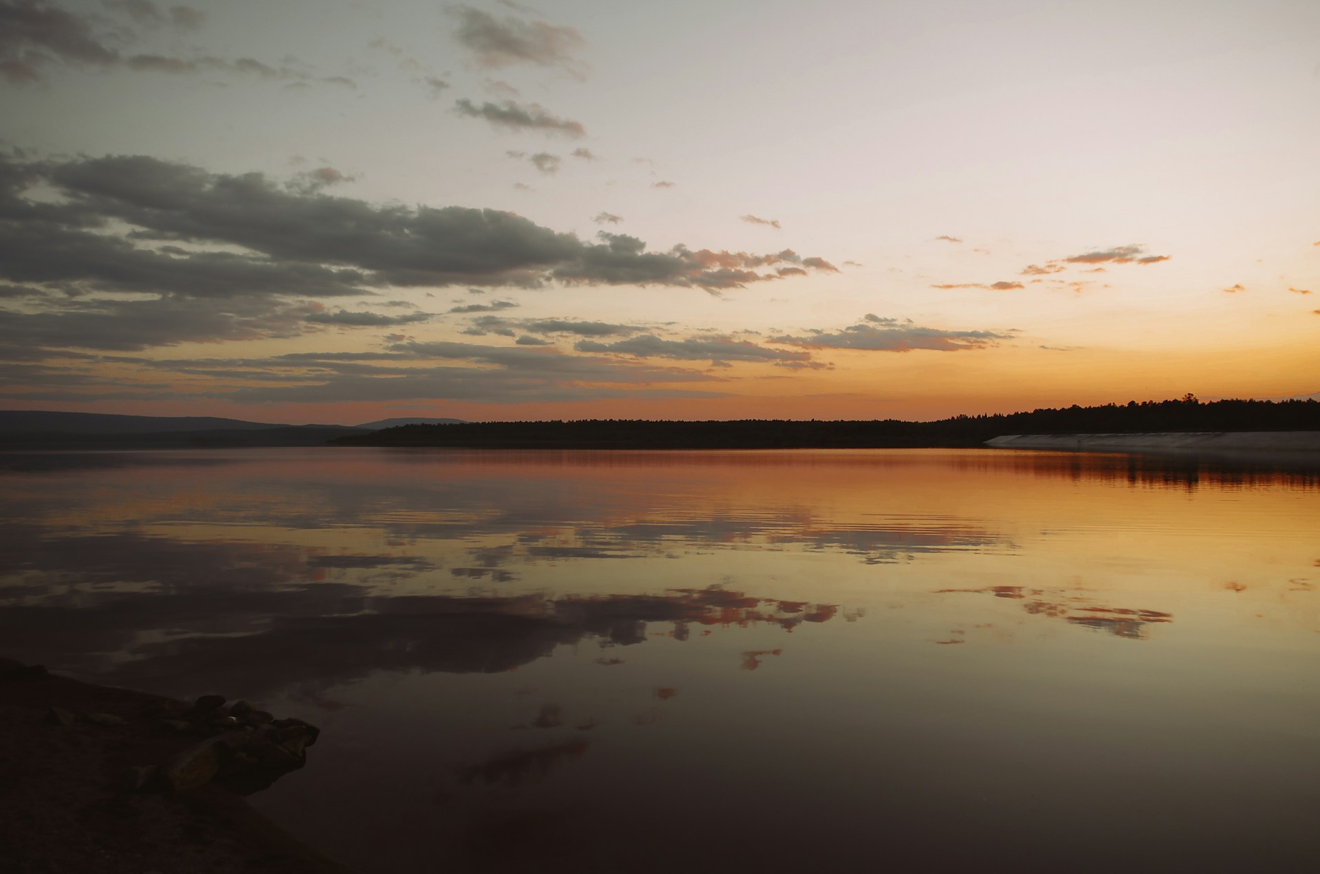 body of water under cloudy sky during sunset