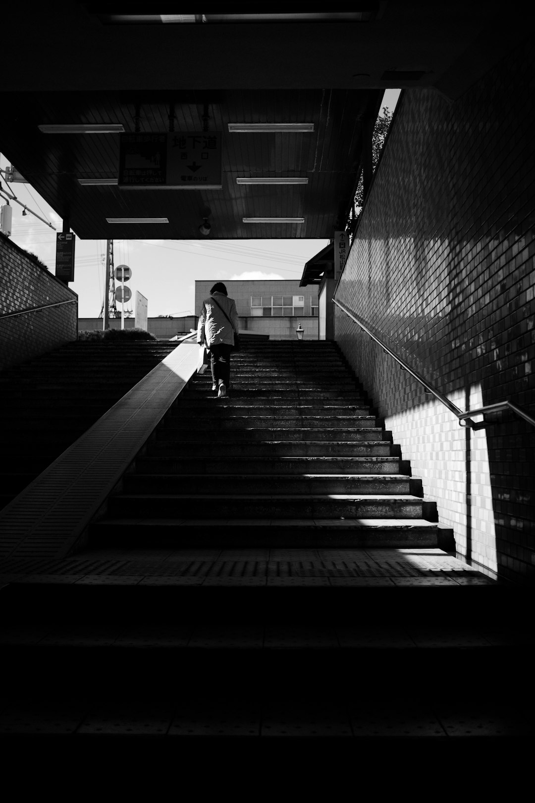 grayscale photo of 2 people walking on stairs
