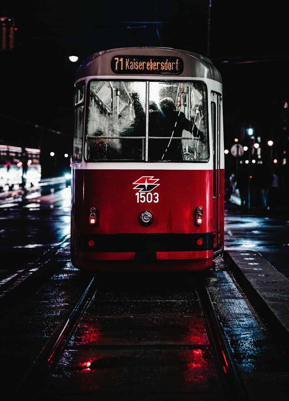 red and white tram on road during night time