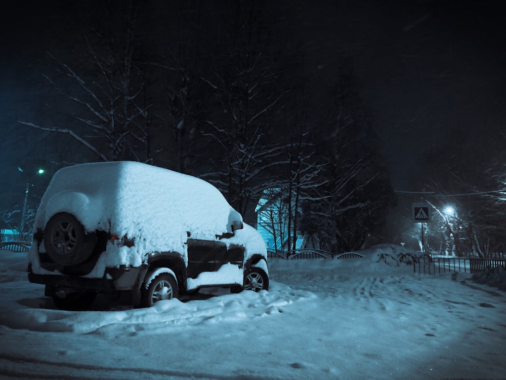 black suv on snow covered road during daytime