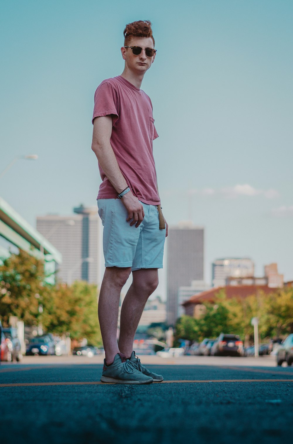 man in red t-shirt and gray shorts standing on field during daytime