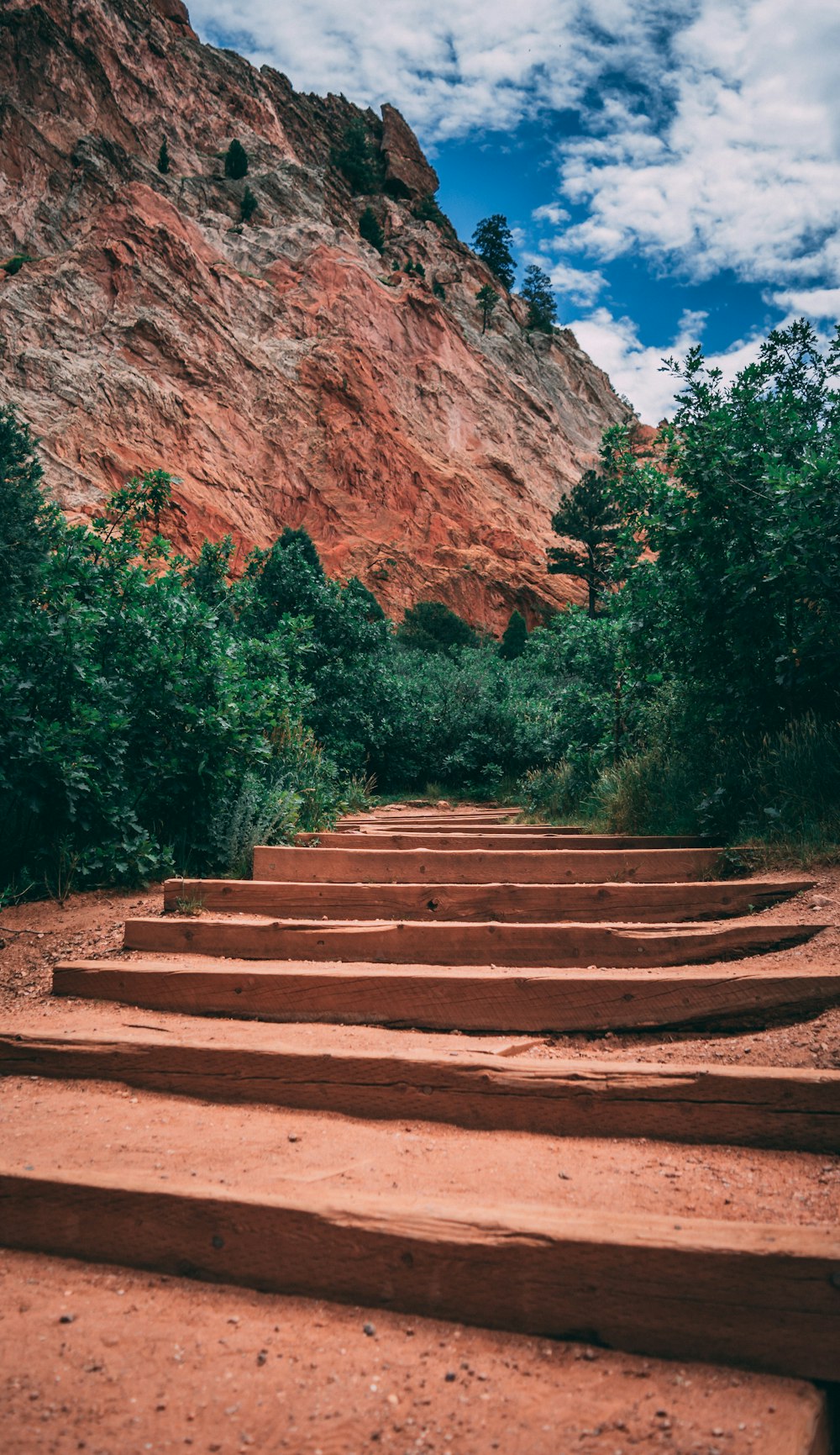 brown wooden stairs near brown rock formation during daytime