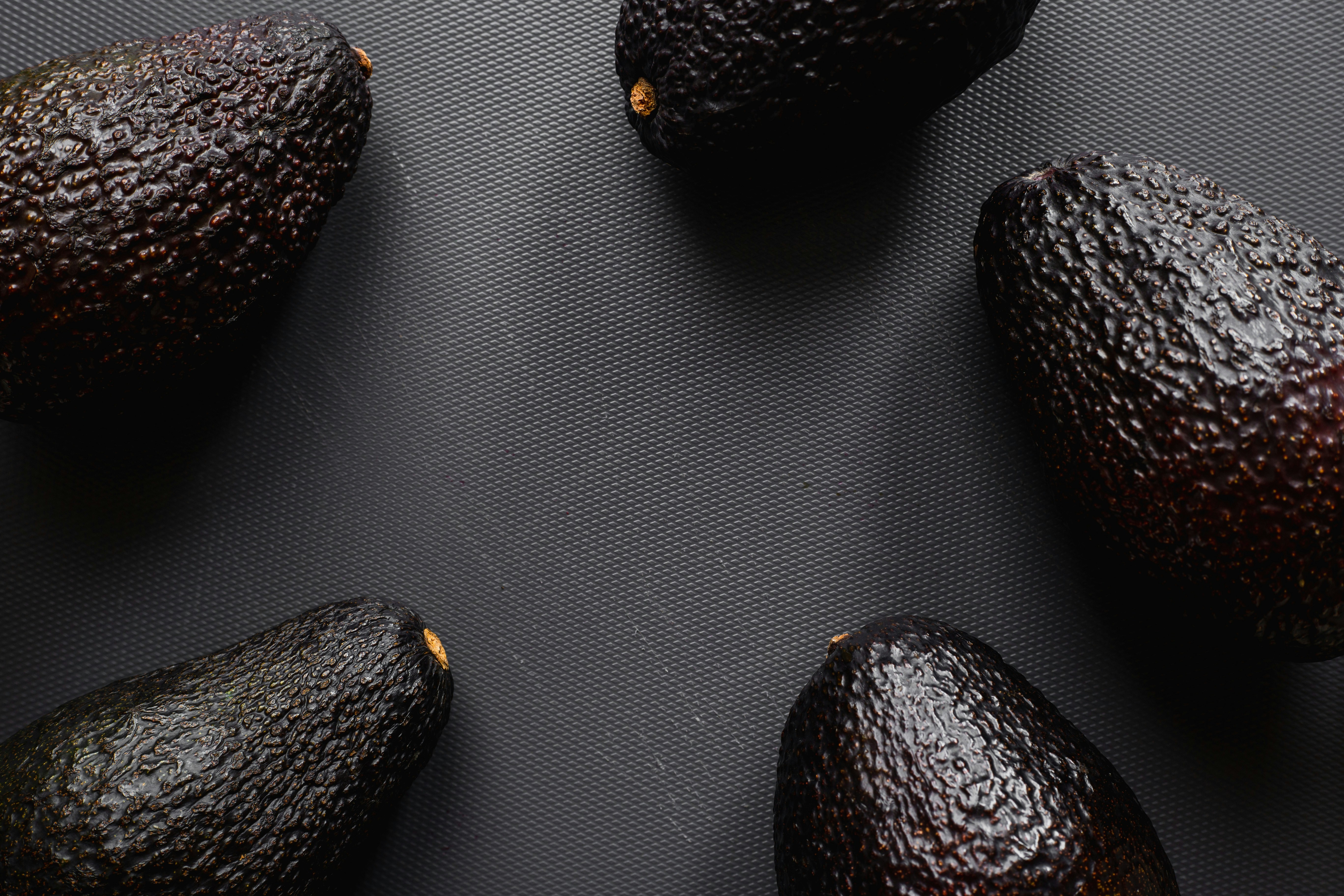 four black and brown fruits
avocados