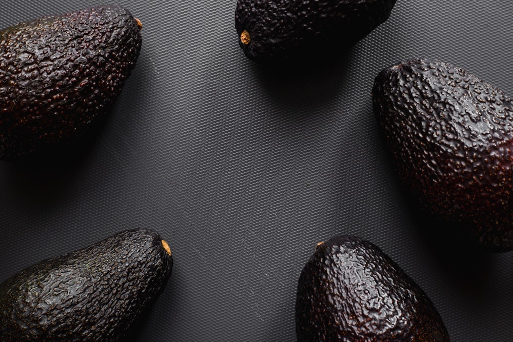 four black and brown fruits