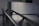 Close-up of a sleek glass railing reflecting soft natural light in a modern interior.