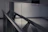 Close-up of a sleek glass railing reflecting soft natural light in a modern interior.
