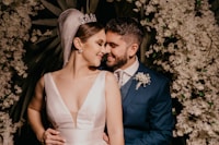 man in blue suit kissing woman in white sleeveless dress