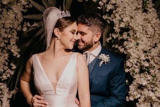 man in blue suit kissing woman in white sleeveless dress