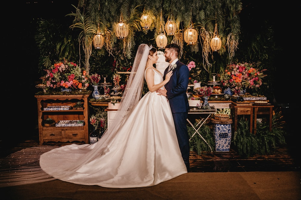 woman in white wedding gown standing beside brown wooden chair