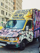 Colorful vehicle wrap graphics on a fleet of company vans in urban setting.