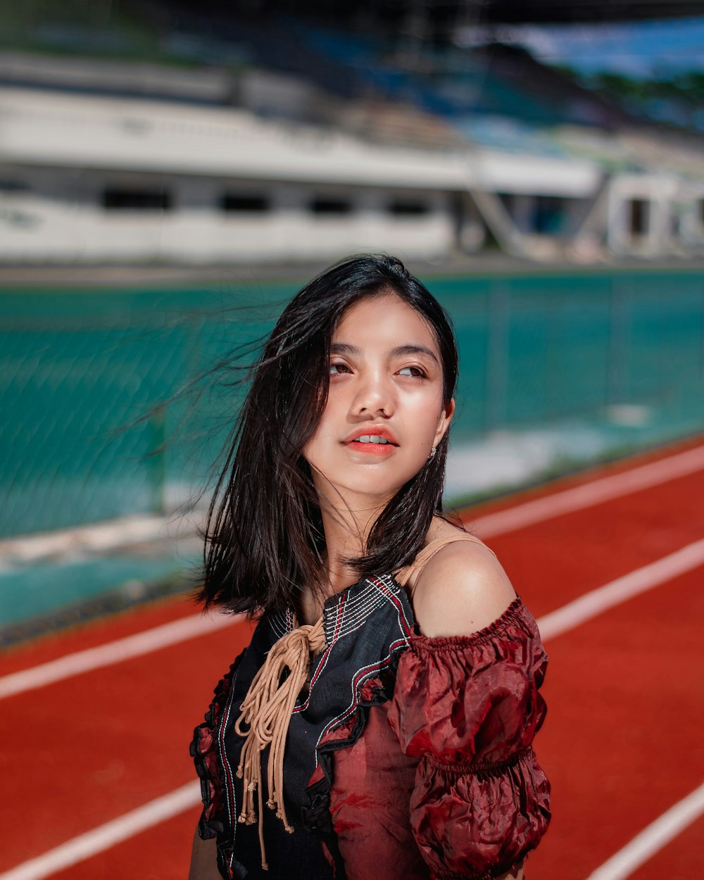 woman in red and black floral dress standing on track field