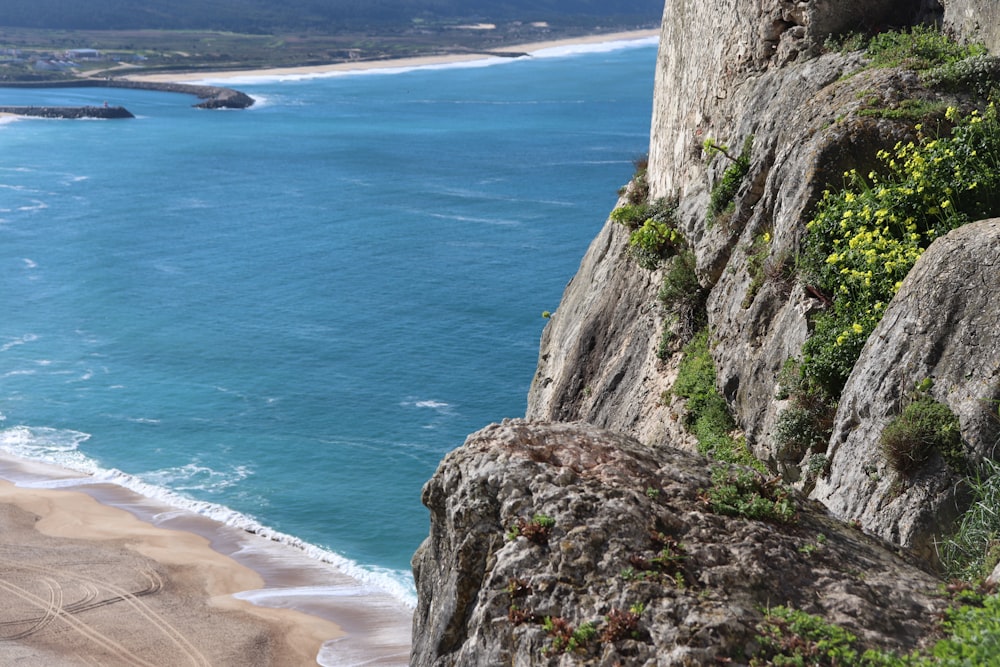 gray rocky mountain beside blue sea during daytime