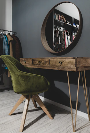 A cozy corner featuring the modern dressing table with a round mirror and minimal accessories.