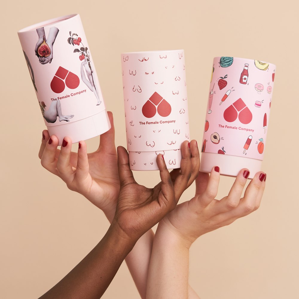 person holding white and pink heart and hearts playing cards