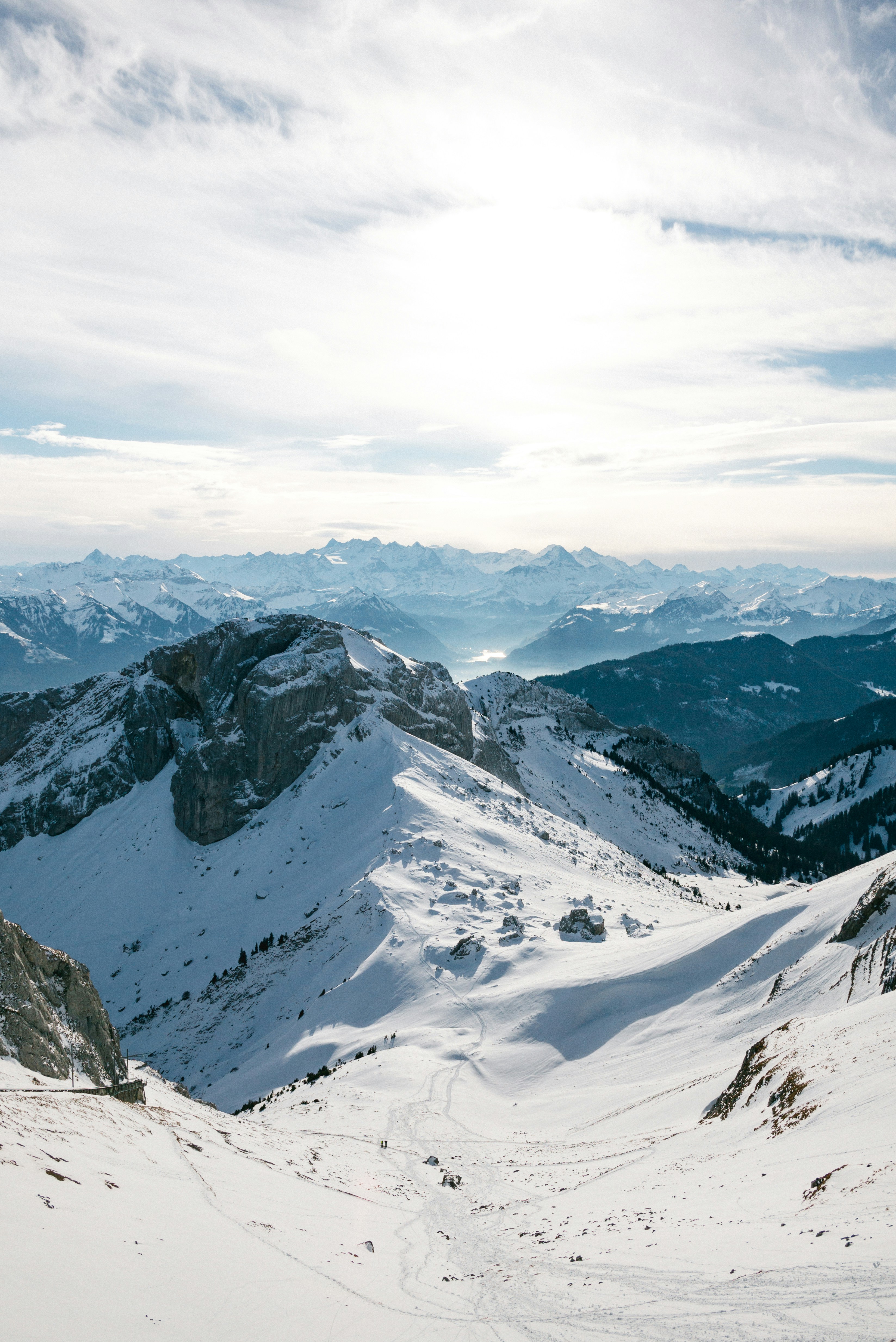 snow covered mountains under cloudy sky during daytime