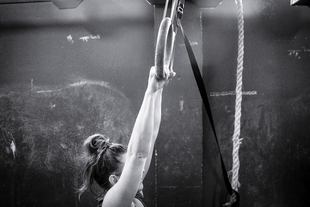 woman in white tank top raising her hands