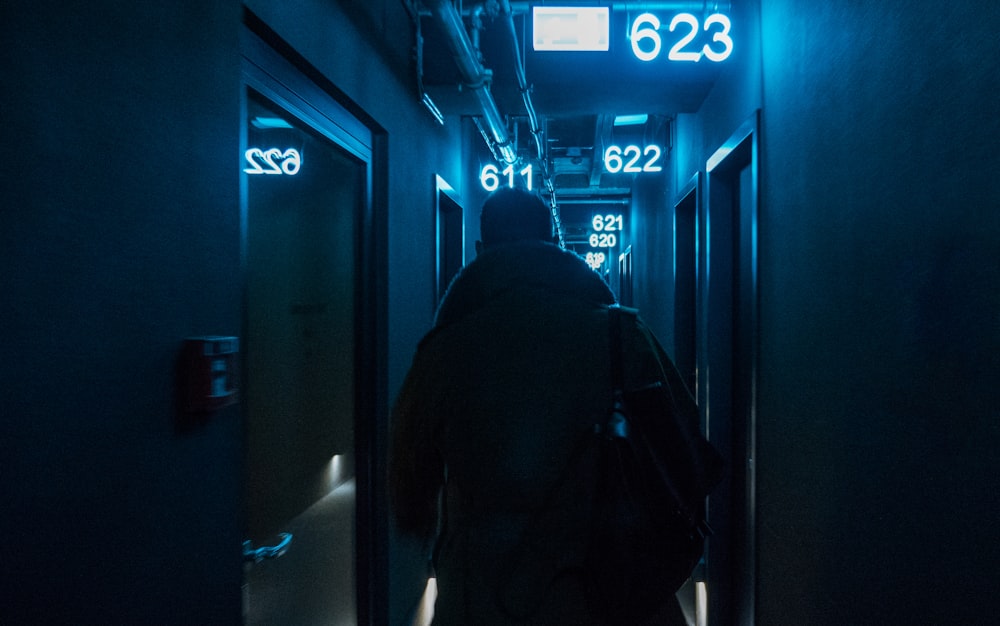 man in black hoodie standing in front of blue door