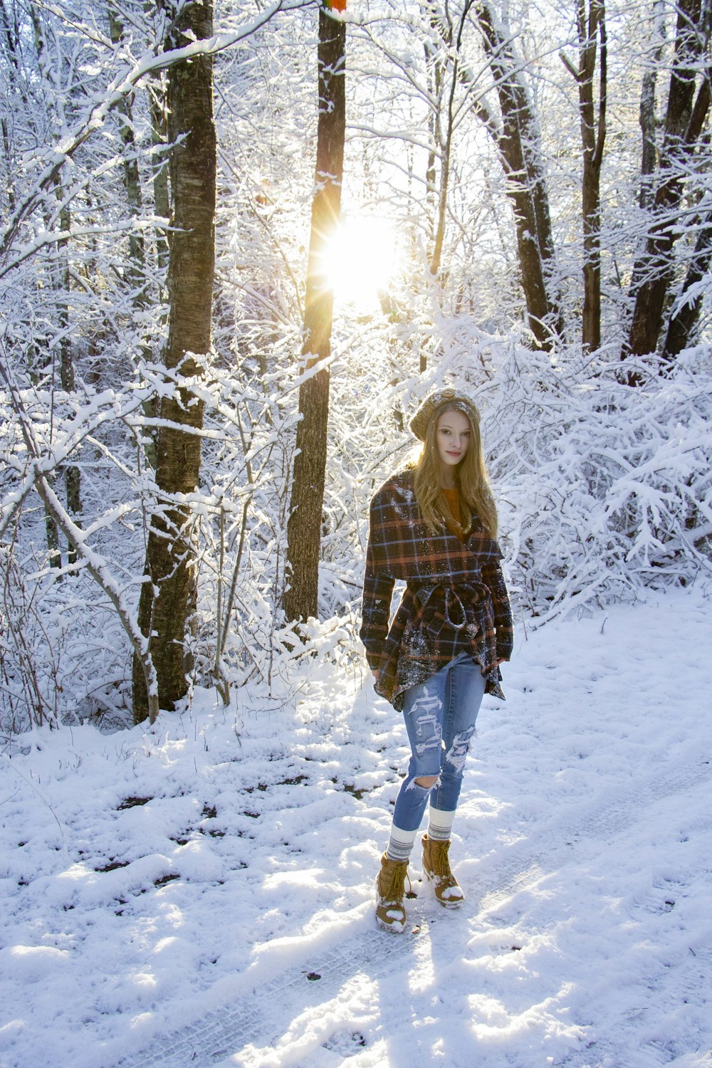 woman in brown jacket standing on snow covered ground during daytime