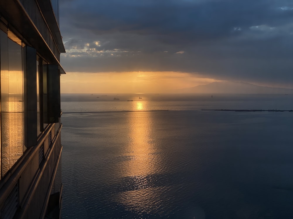 brown wooden house on sea during sunset