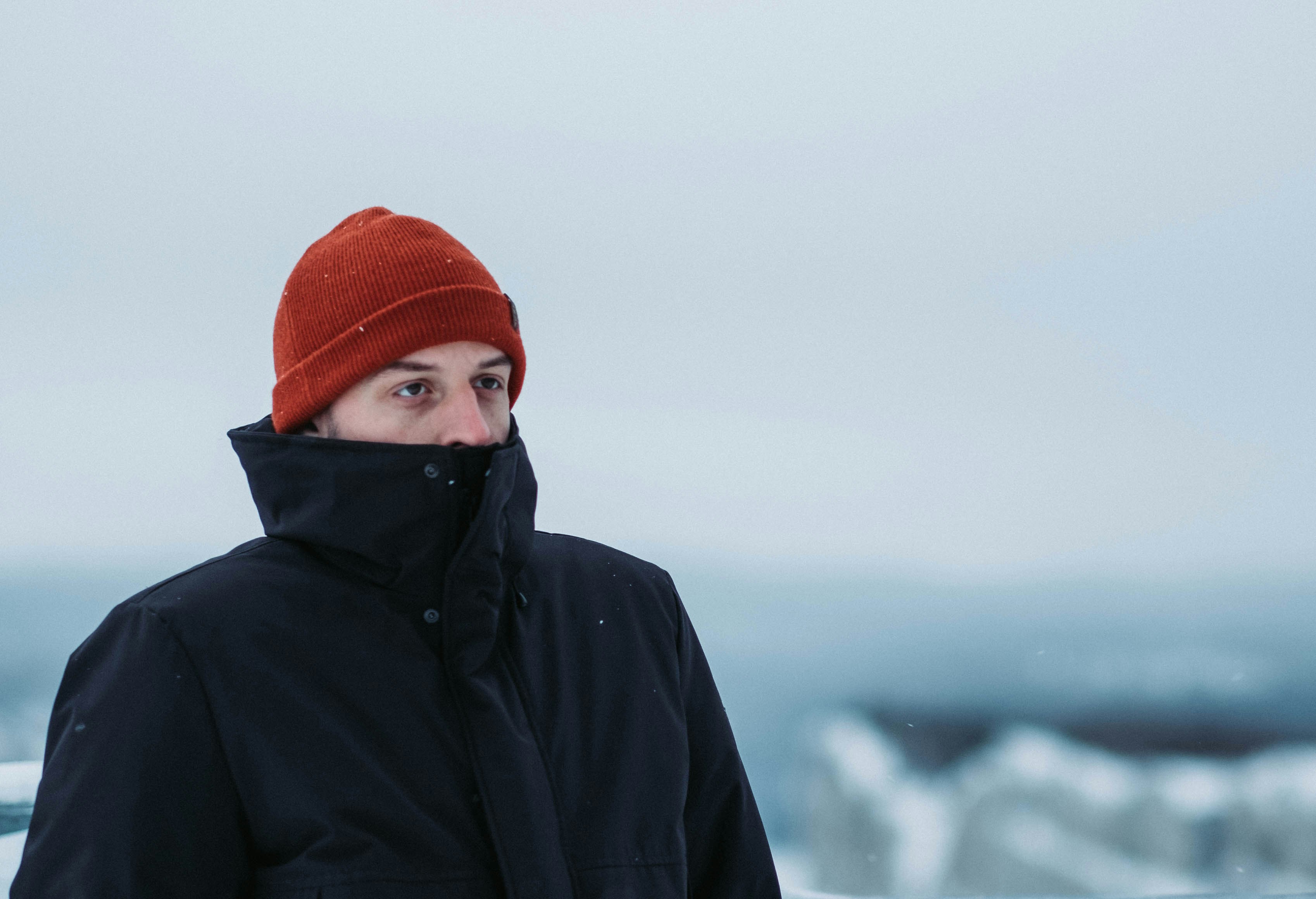 person in black hoodie and orange knit cap