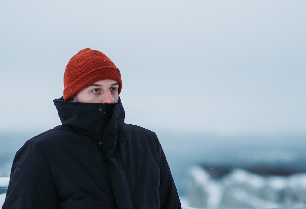 person in black hoodie and orange knit cap