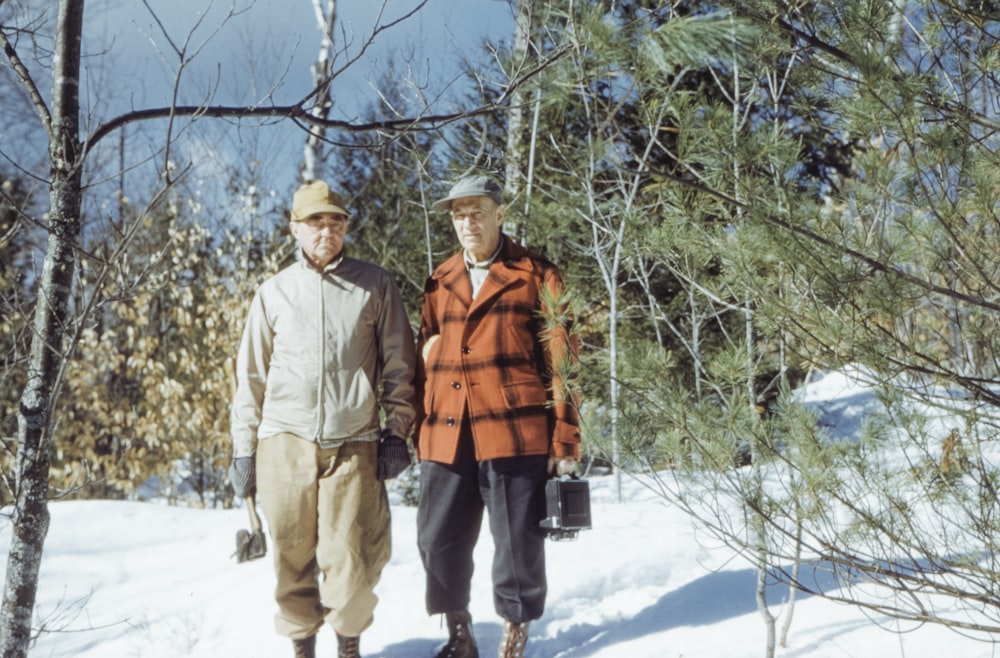 man in brown jacket standing on snow covered ground during daytime