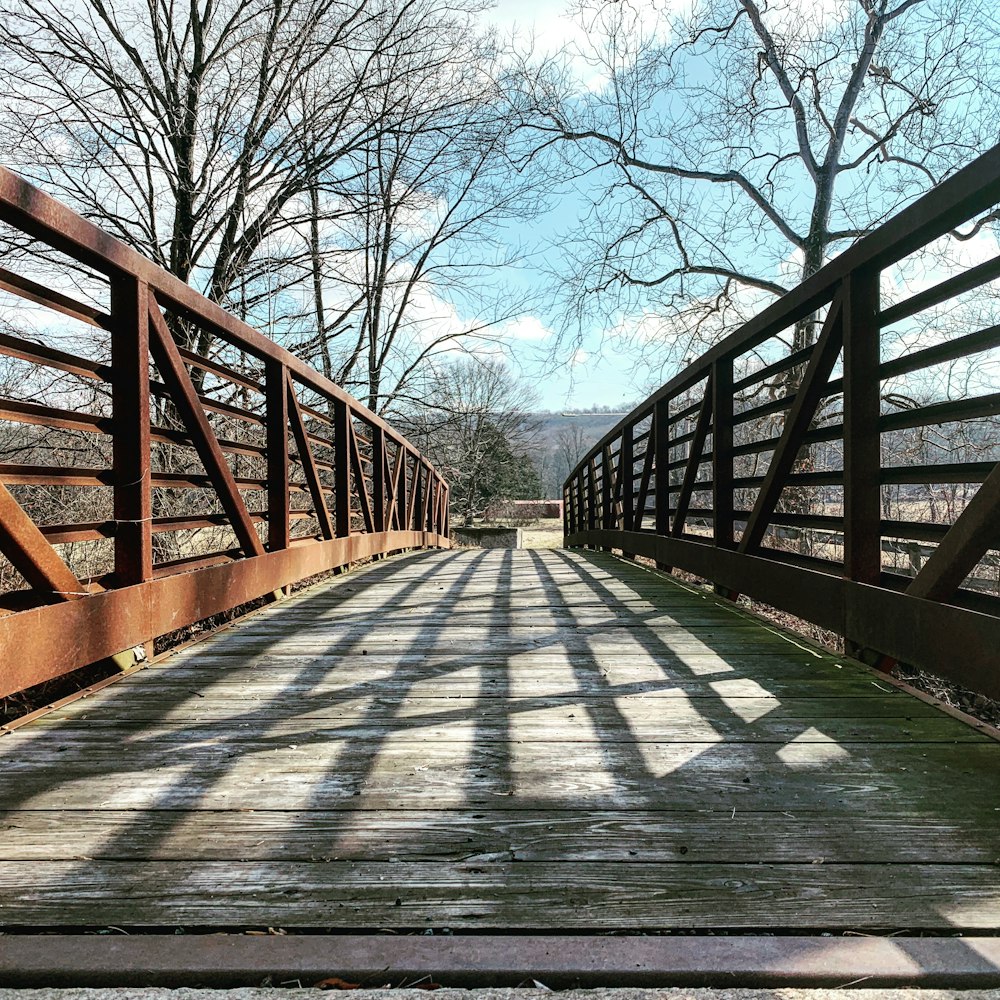 Puente de madera marrón bajo el cielo azul durante el día