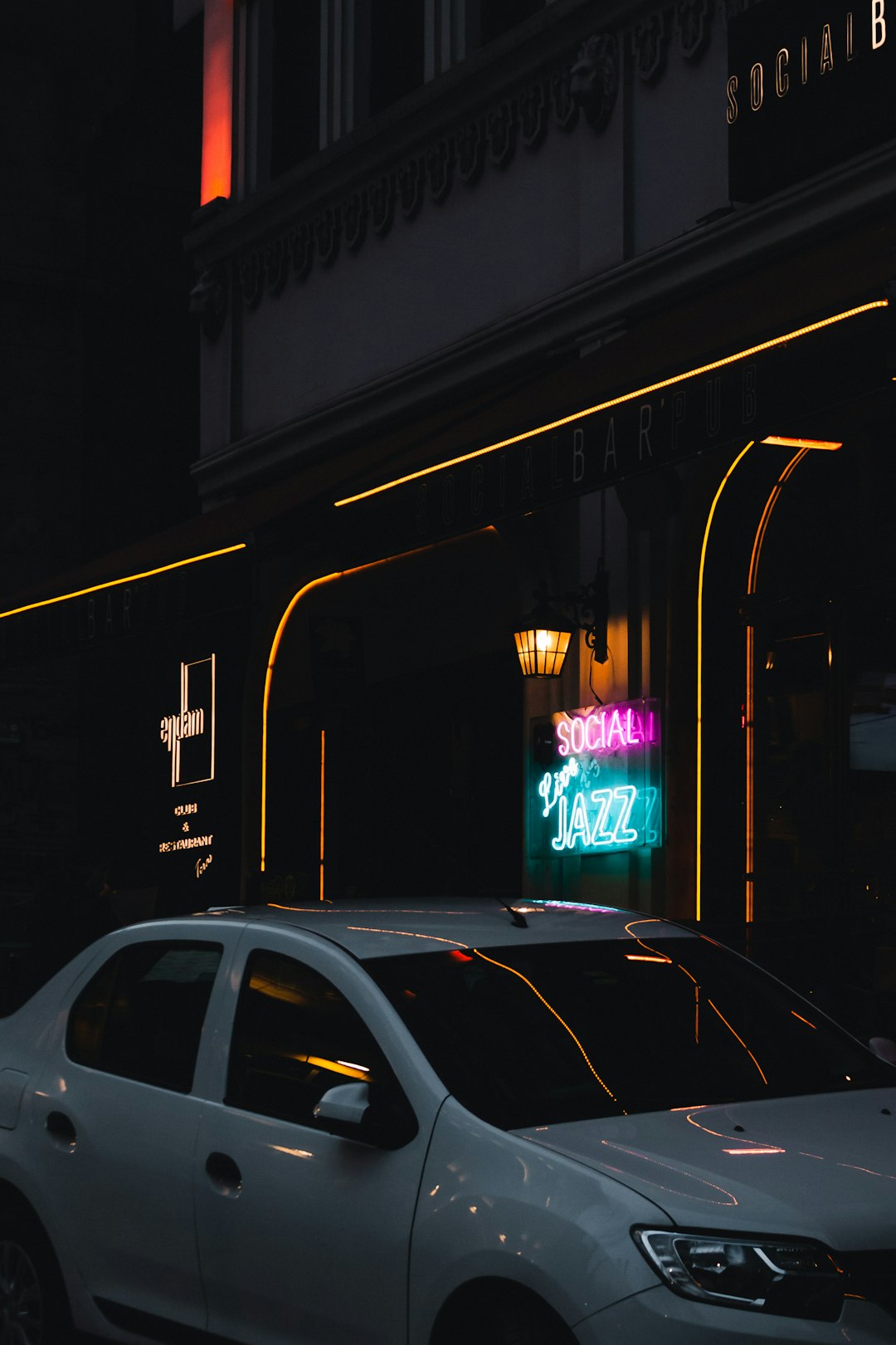 white car parked beside store during night time