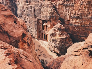 brown and white concrete building on brown rocky mountain during daytime