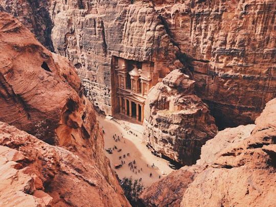 brown and white concrete building on brown rocky mountain during daytime in Petra Jordan