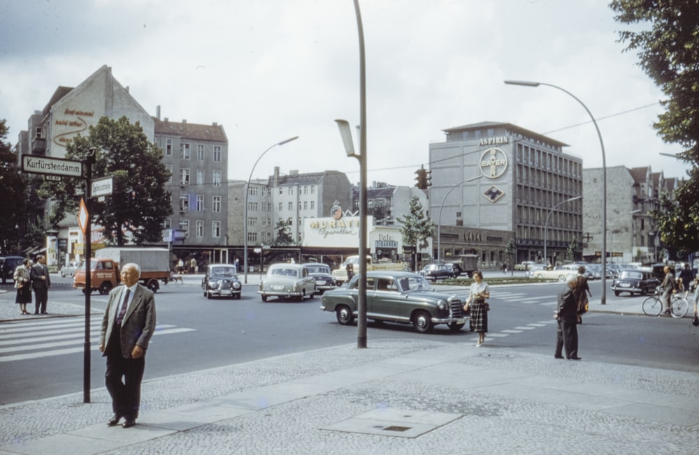 man in black jacket standing on sidewalk during daytime