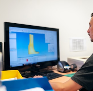 man in black t-shirt sitting in front of computer