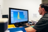 man in black t-shirt sitting in front of computer