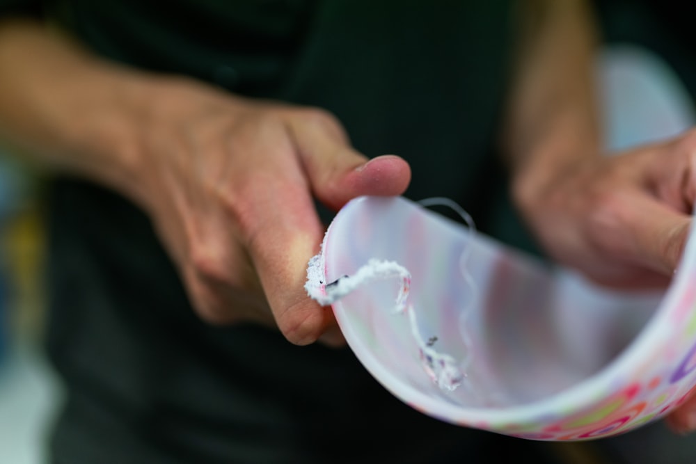 person holding white plastic cup