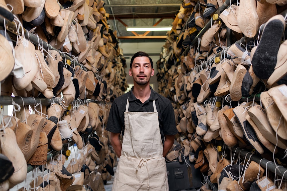 man in black vest and white apron standing