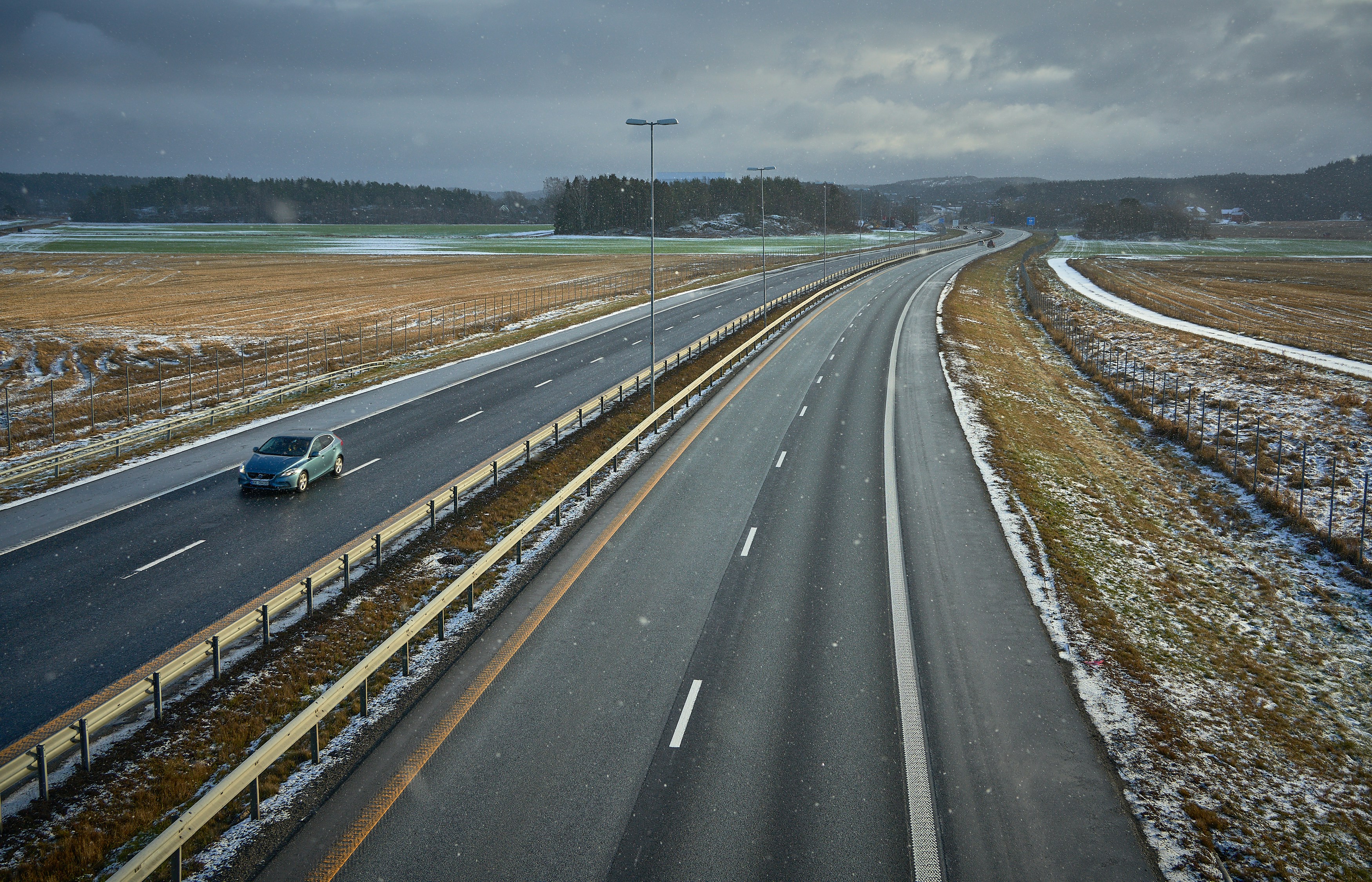 Electric SUV driving on an open highway with hills in the distance