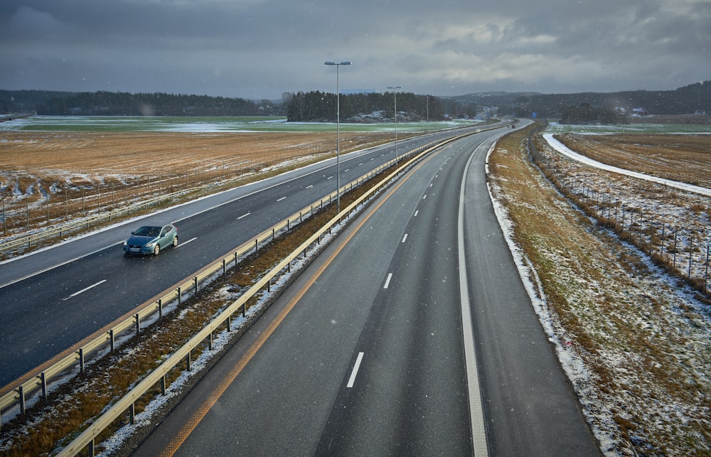 blue car on gray asphalt road during daytime