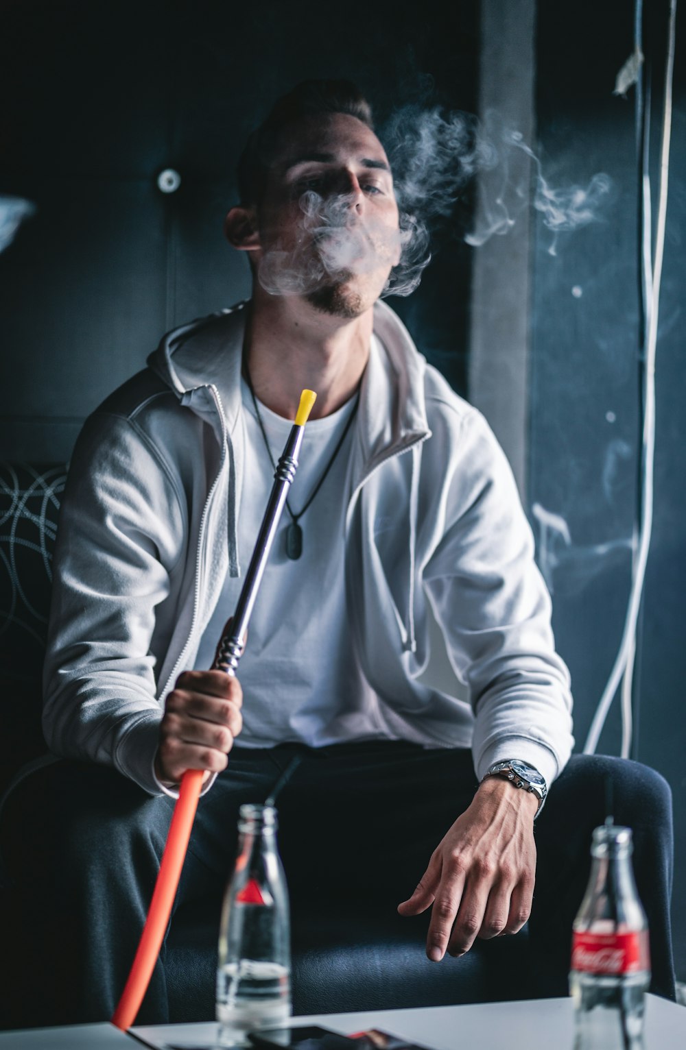 man in white zip up jacket holding red stick