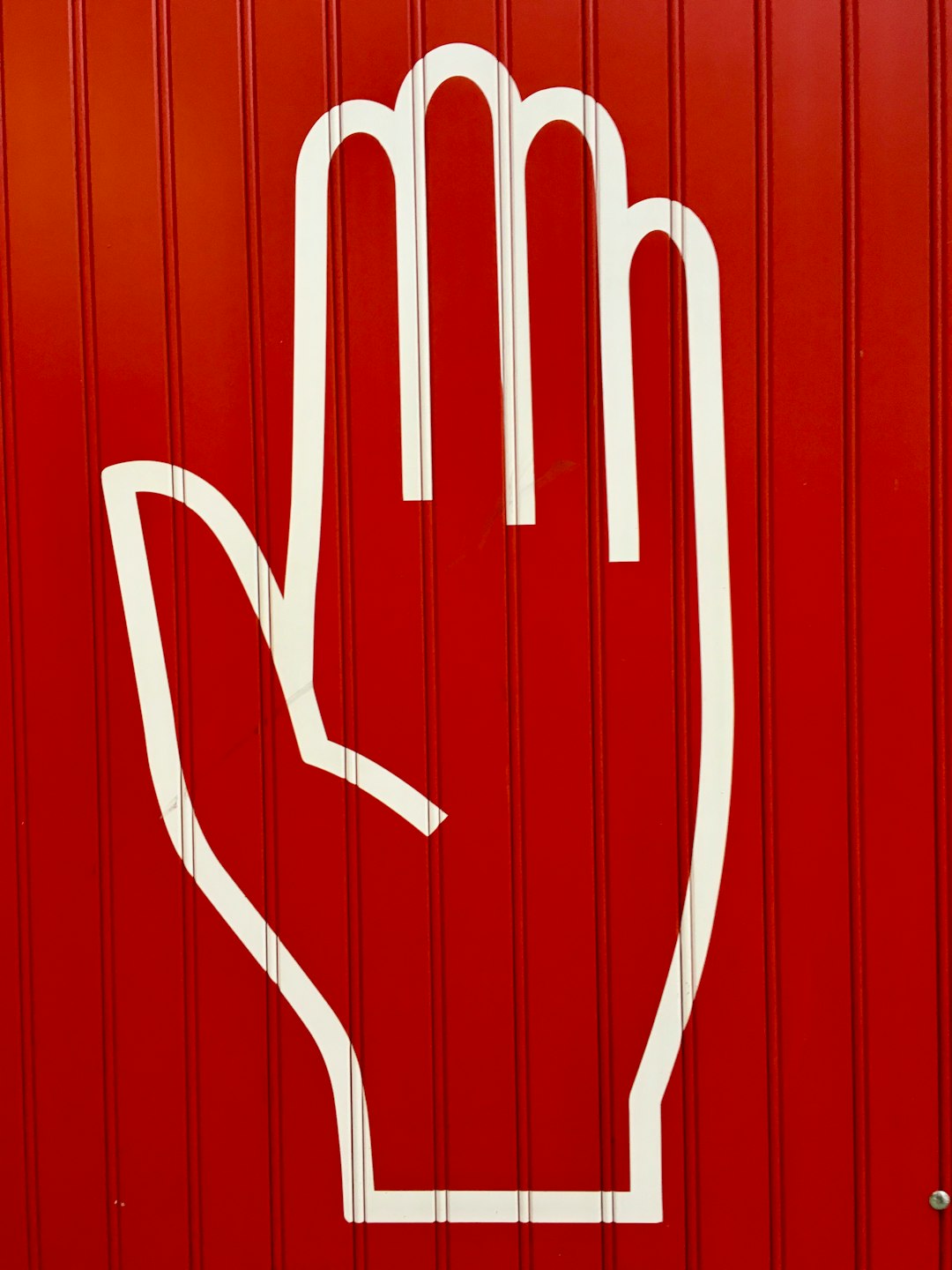 white outline of a hand on a red background