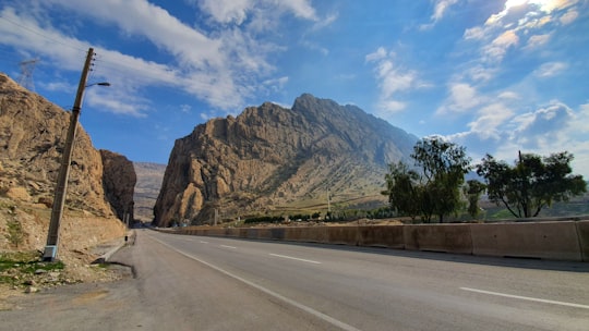 gray asphalt road near brown mountain under blue sky during daytime in Shiraz Iran