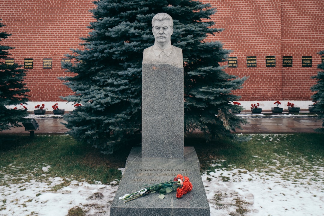 gray concrete statue near red brick building