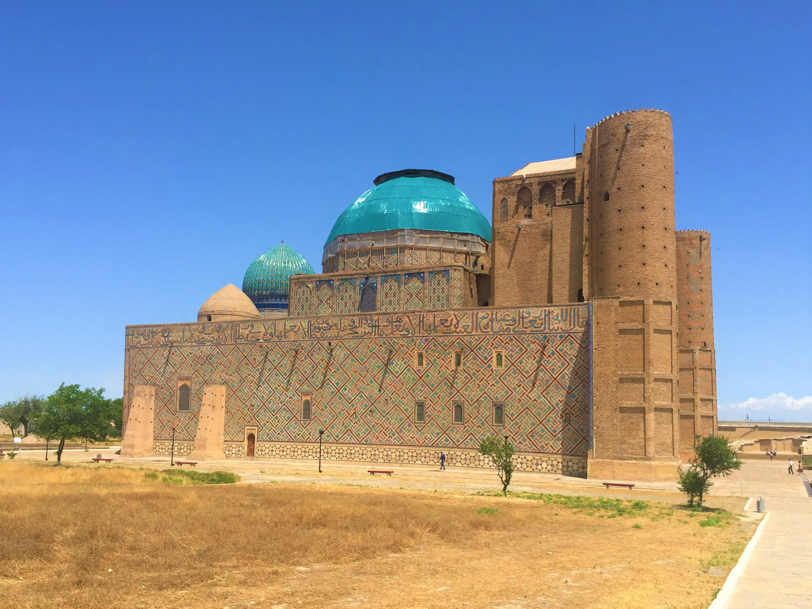 The Mausoleum of Khoja Ahmed Yasawi in Turkistan, its turquoise domes and the unfinished brick portal