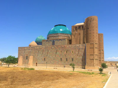 The Mausoleum of Khoja Ahmed Yasawi in Turkistan, its turquoise domes and the unfinished brick portal